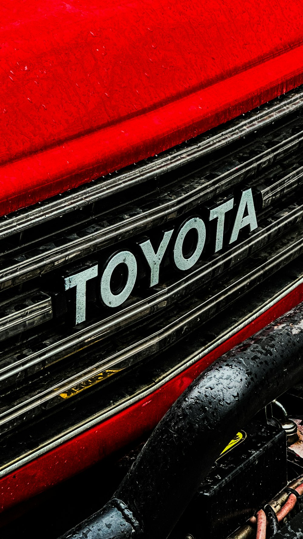 Gros plan d’un logo Toyota sur une voiture rouge