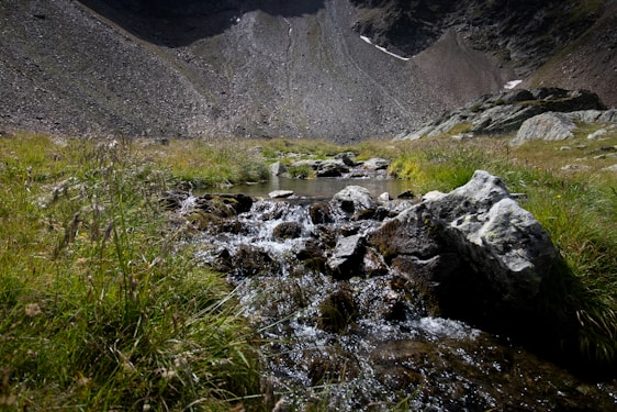 A serene landscape featuring clear, flowing water with mountains in the background.