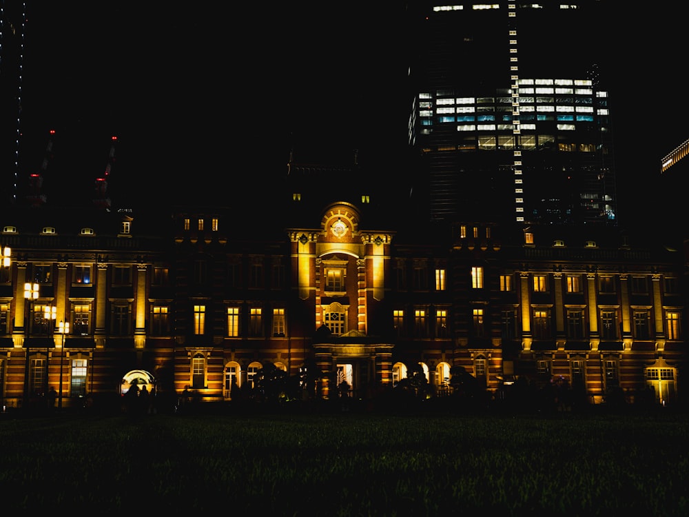 a large building lit up at night with a clock on it