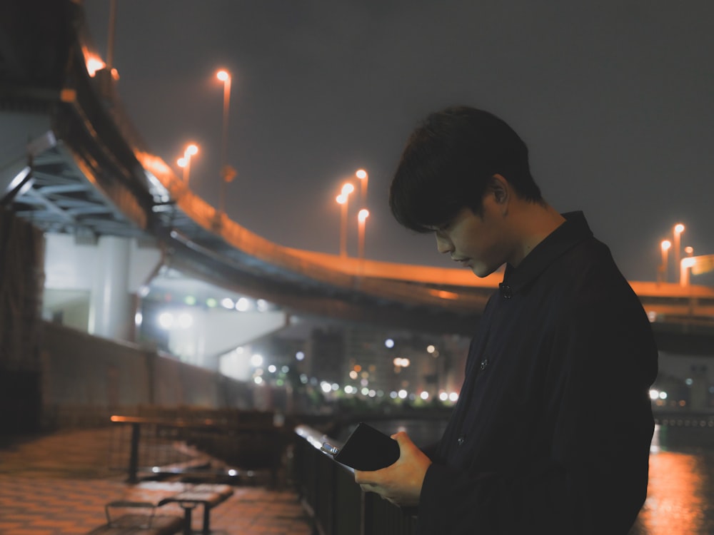 a man looking at his cell phone at night