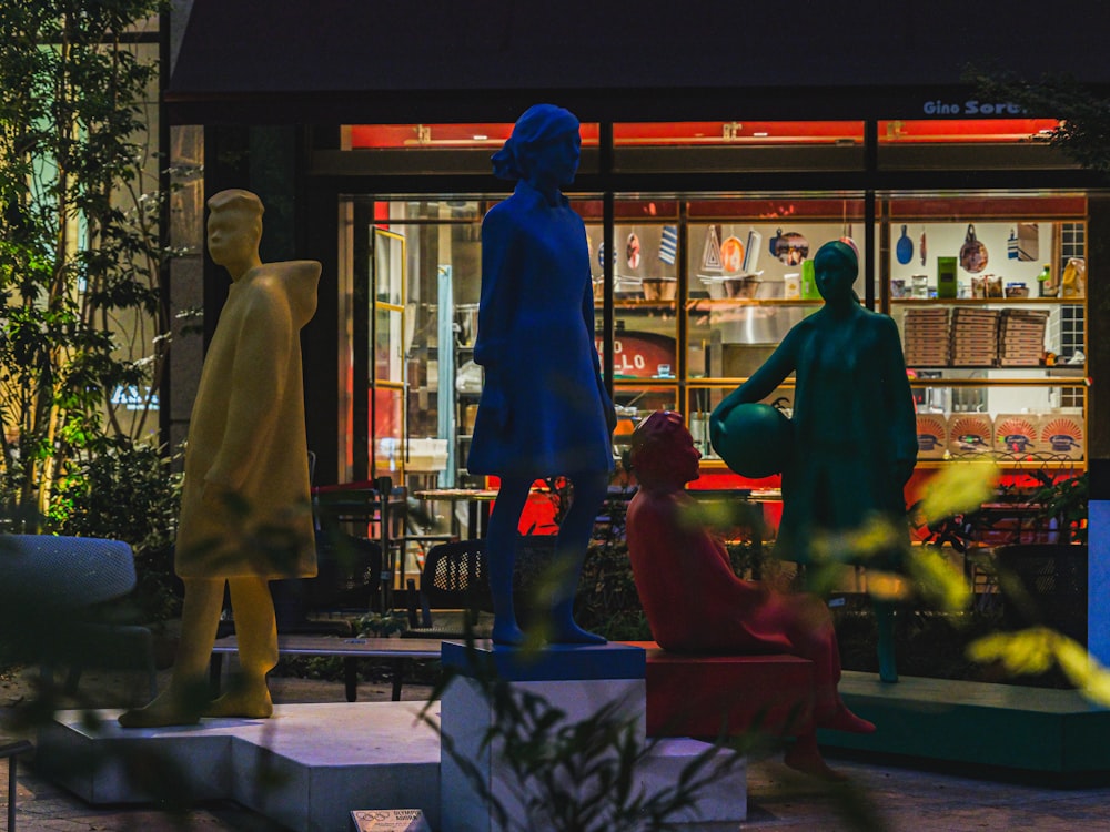 a couple of statues of people sitting in front of a store