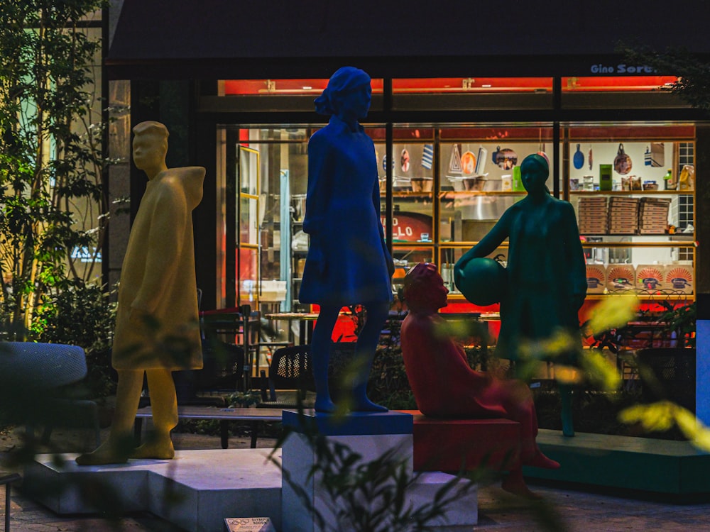 Un par de estatuas de personas sentadas frente a una tienda
