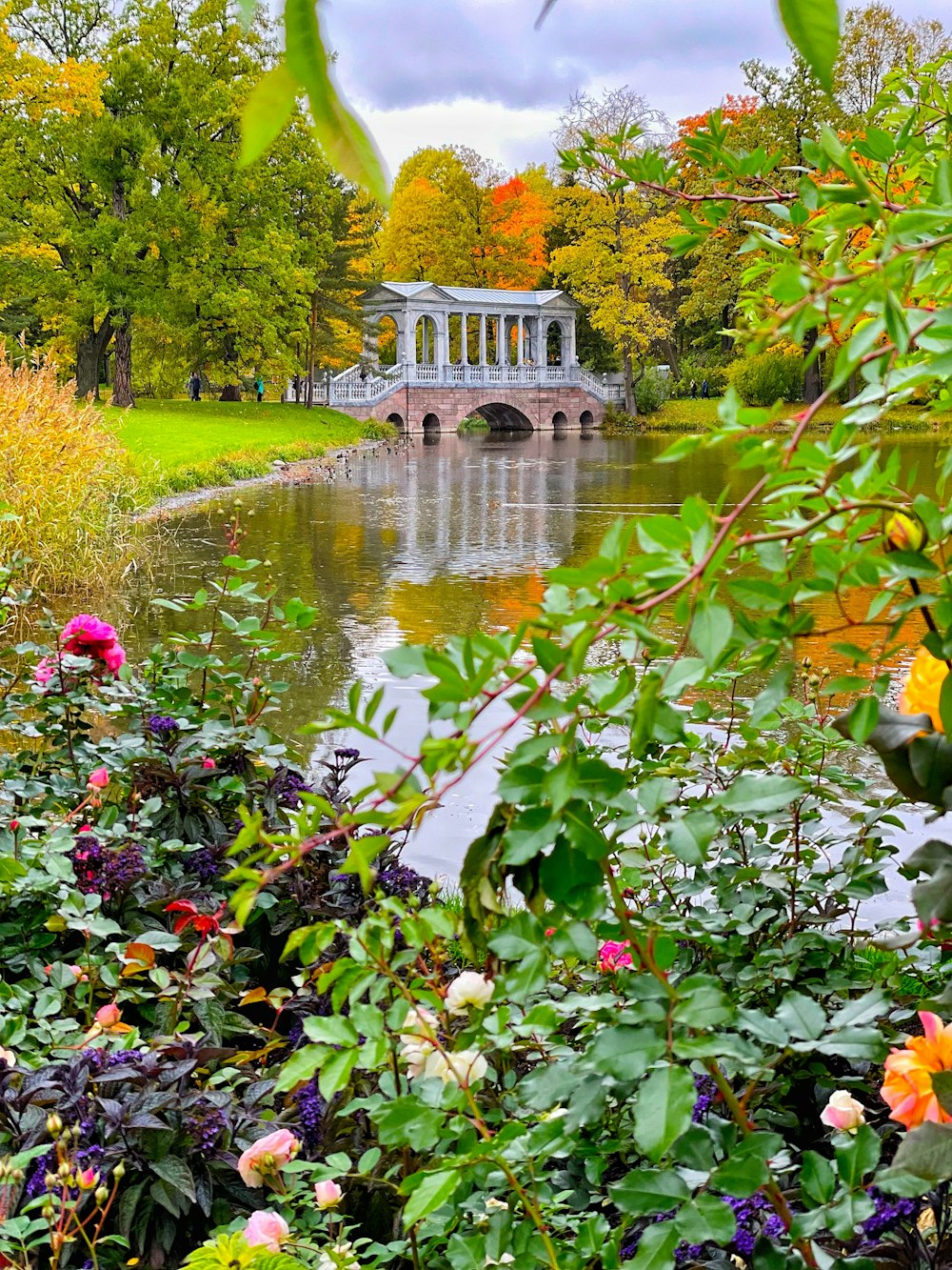 a bridge over a river surrounded by lots of flowers