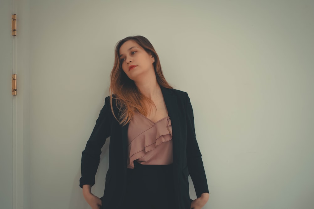 a woman standing in front of a white wall