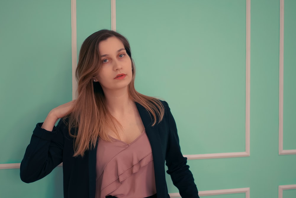 a woman standing in front of a green wall