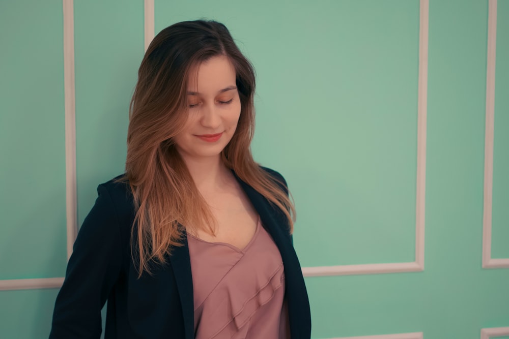 a woman standing in front of a green wall