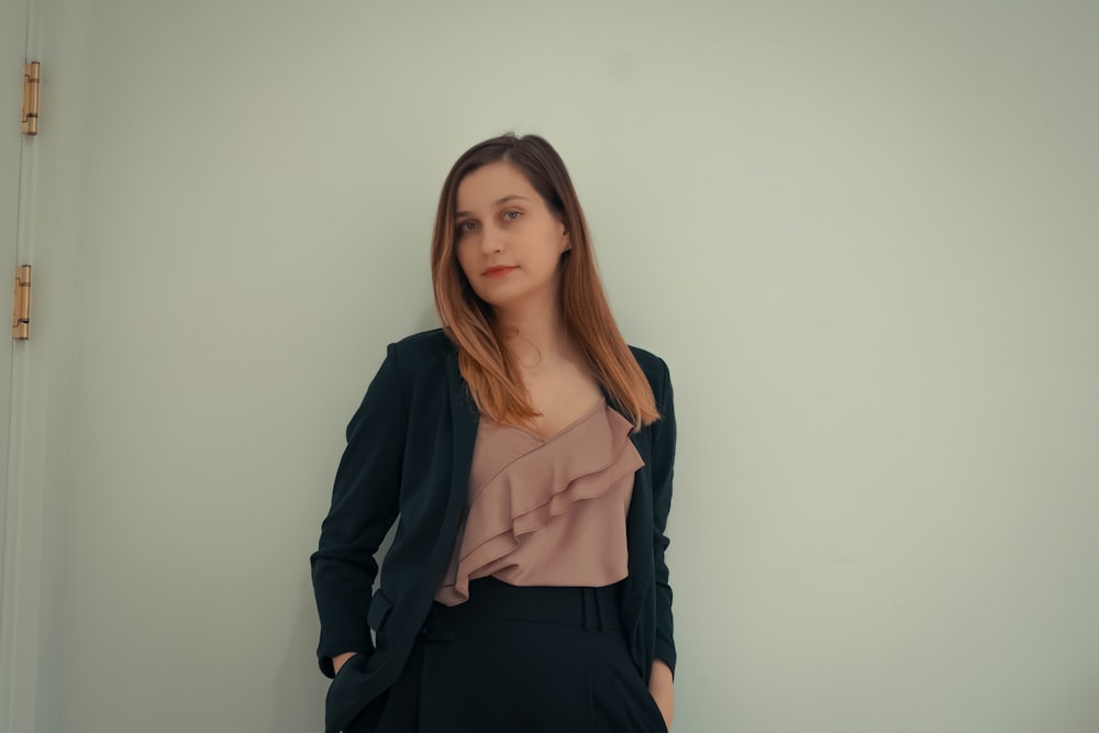 a woman standing in front of a white wall