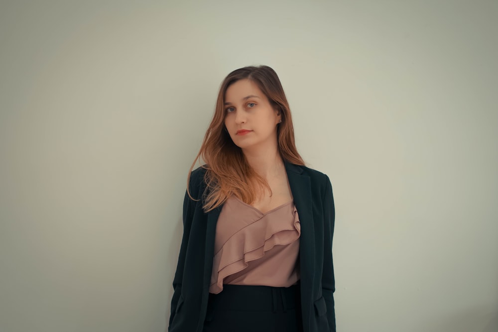 a woman standing in front of a white wall