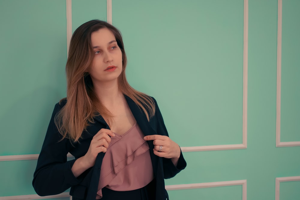 a woman standing in front of a green wall