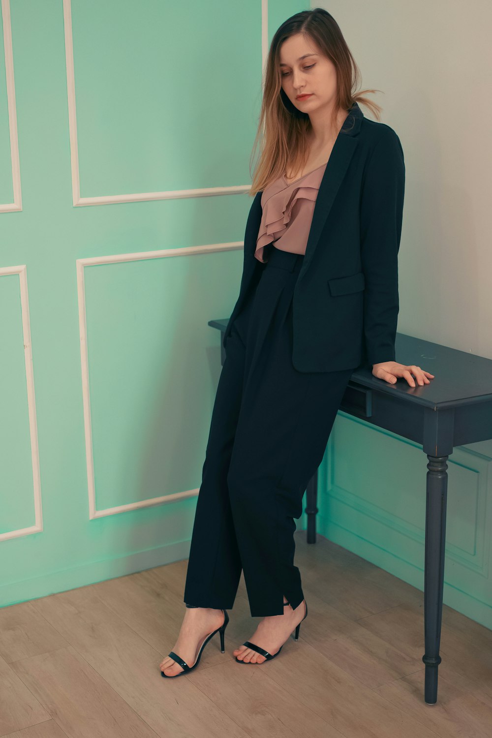 a woman in a black suit standing next to a table