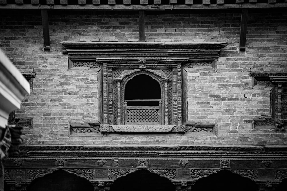 a black and white photo of a window in a brick building