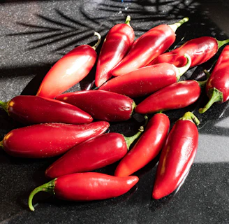 a pile of red peppers sitting on top of a counter