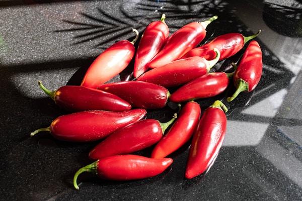 Bright red Guntur chili peppers arranged artfully on a wooden table, capturing their fiery appeal.