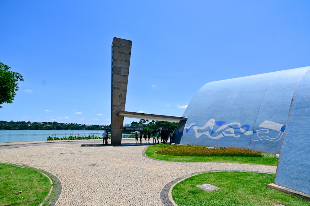 a large blue sculpture sitting on top of a lush green field