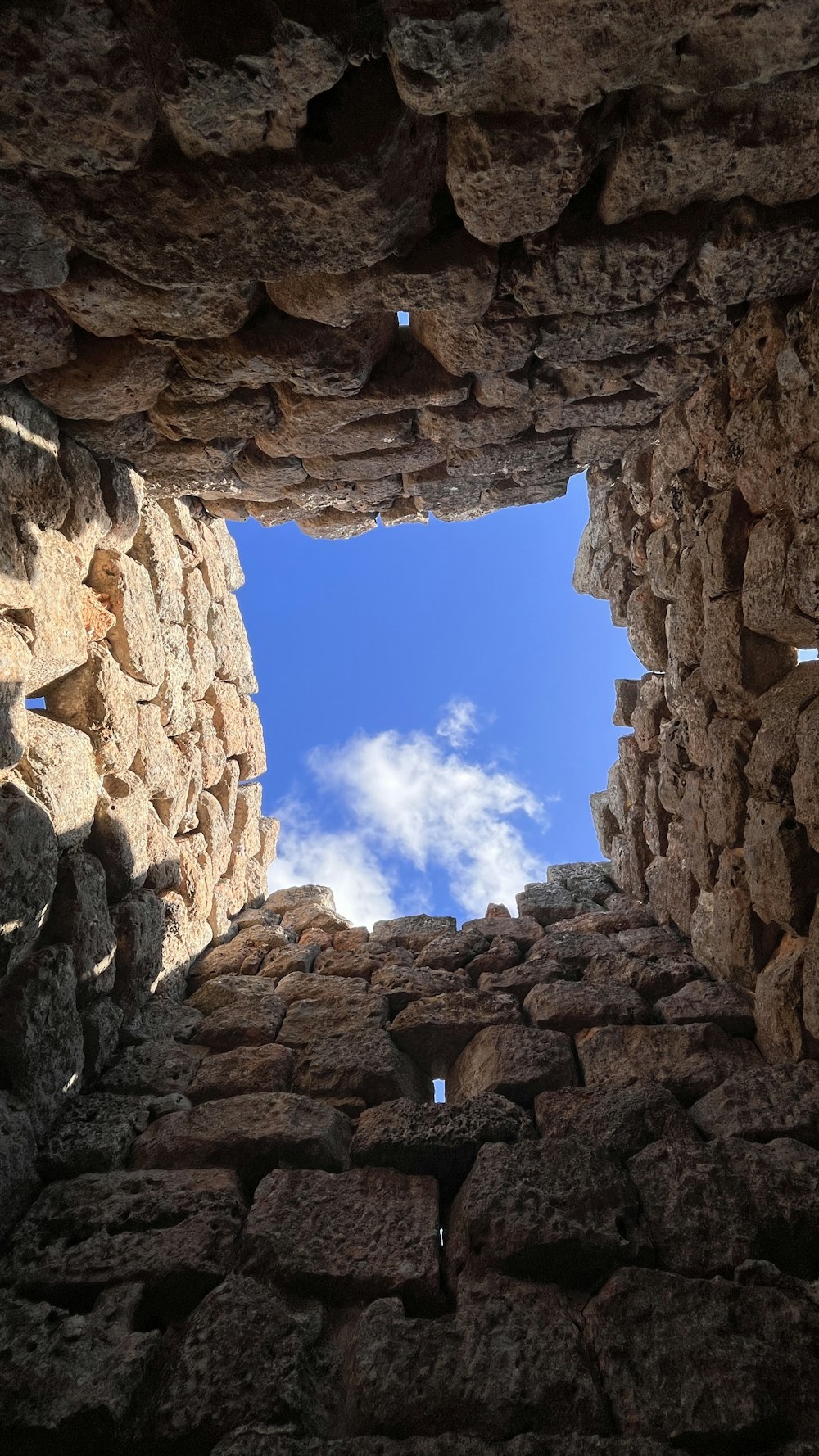 a view of the sky through a window in a stone structure