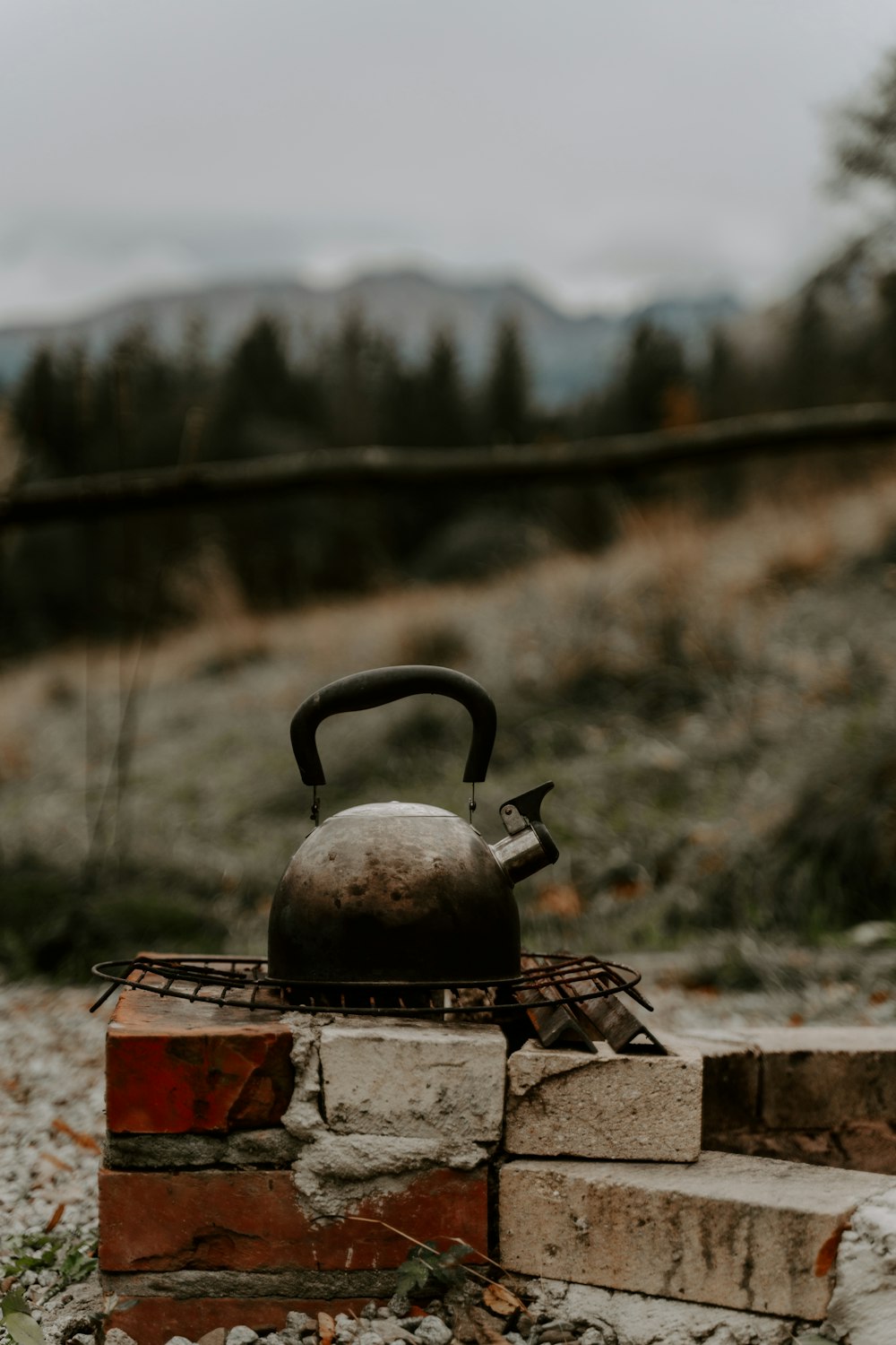 a kettle sitting on top of a brick wall