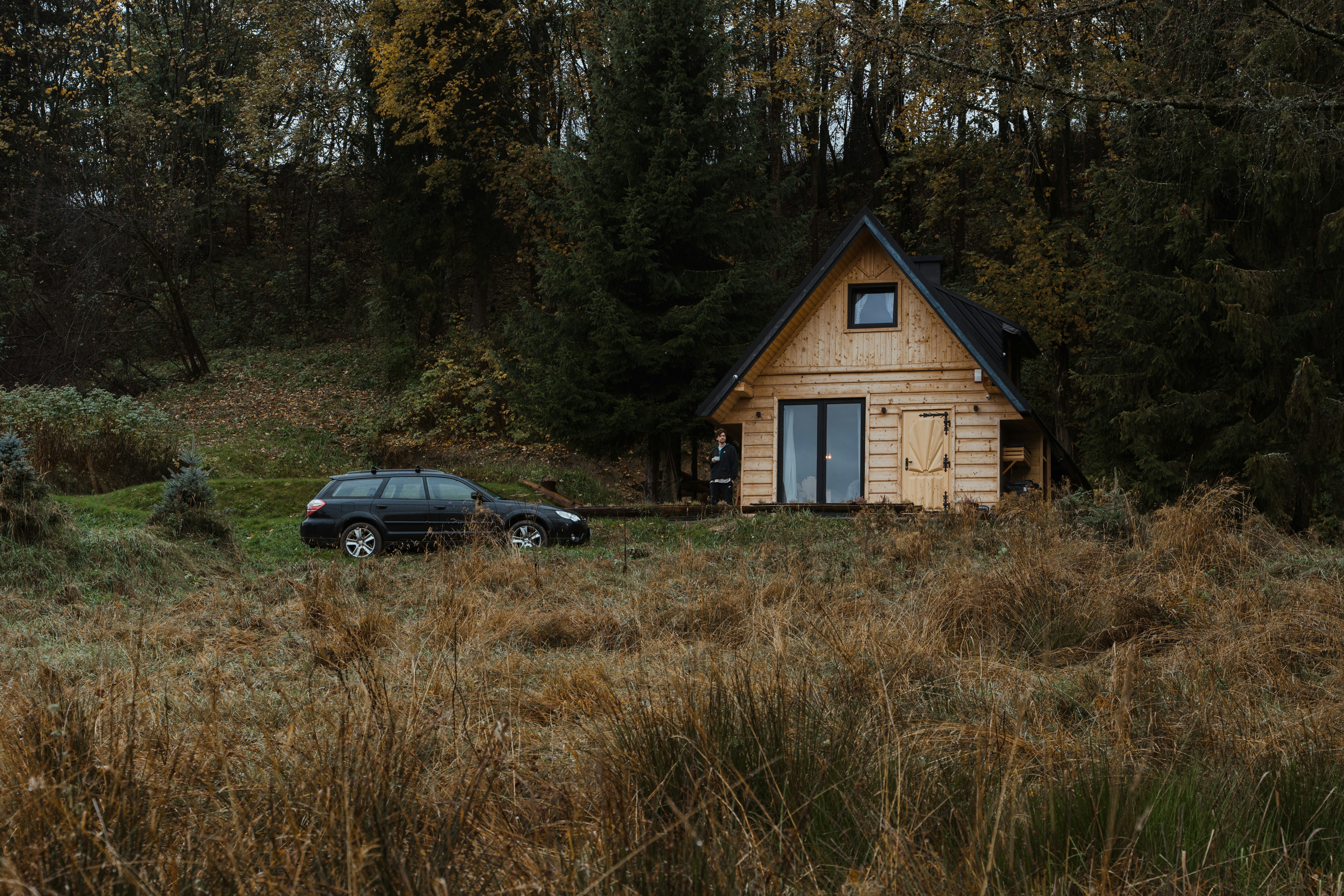 a car parked in front of a wooden cabin