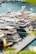 A marina filled with luxury yachts docked along the pier. The water is a clear blue and the scene is framed by vibrant green foliage. The yachts are sleek, with modern designs, and display various national flags.