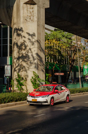 A taxi cruising along a leafy suburban road in Bexleyheath on a sunny afternoon.