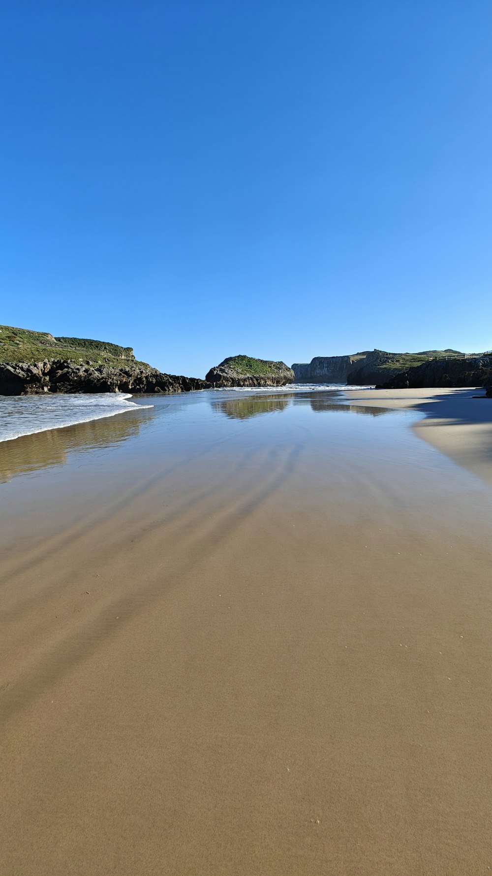 a body of water sitting on top of a sandy beach