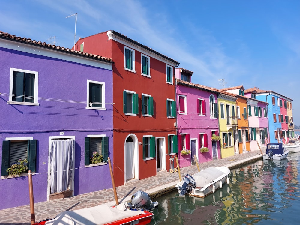 a row of colorful houses next to a body of water
