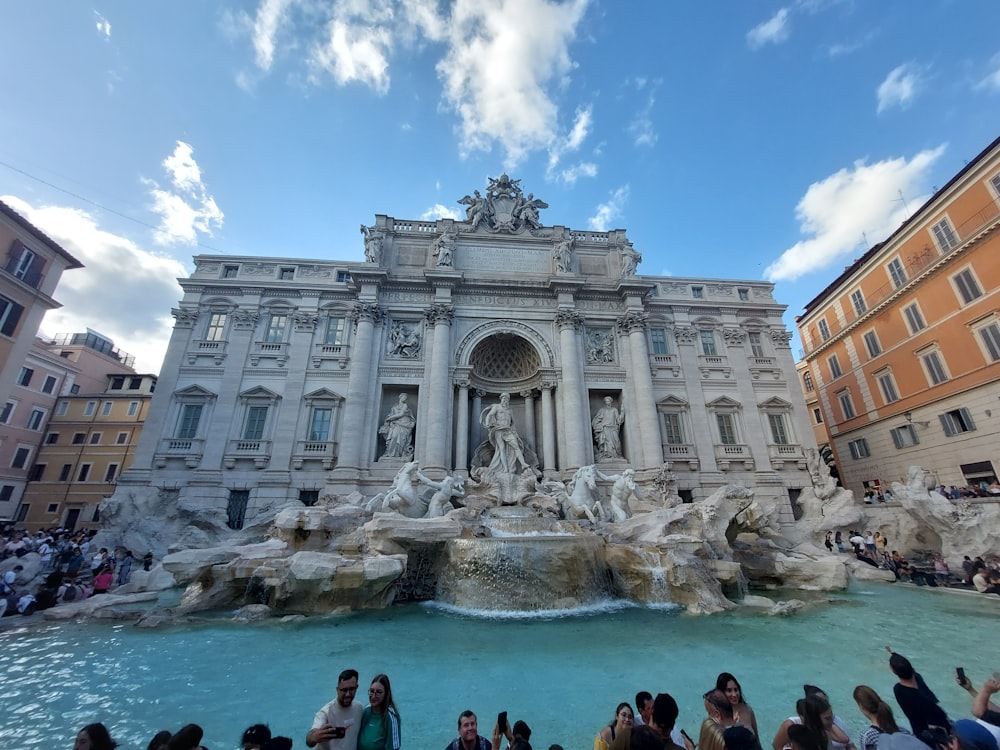 a group of people standing around a fountain