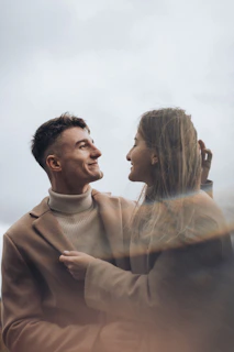Warm, spontaneous portrait of a couple sharing a quiet moment outdoors in soft terracotta tones.