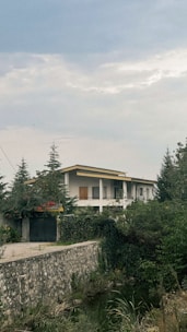 a large white house sitting on top of a lush green hillside