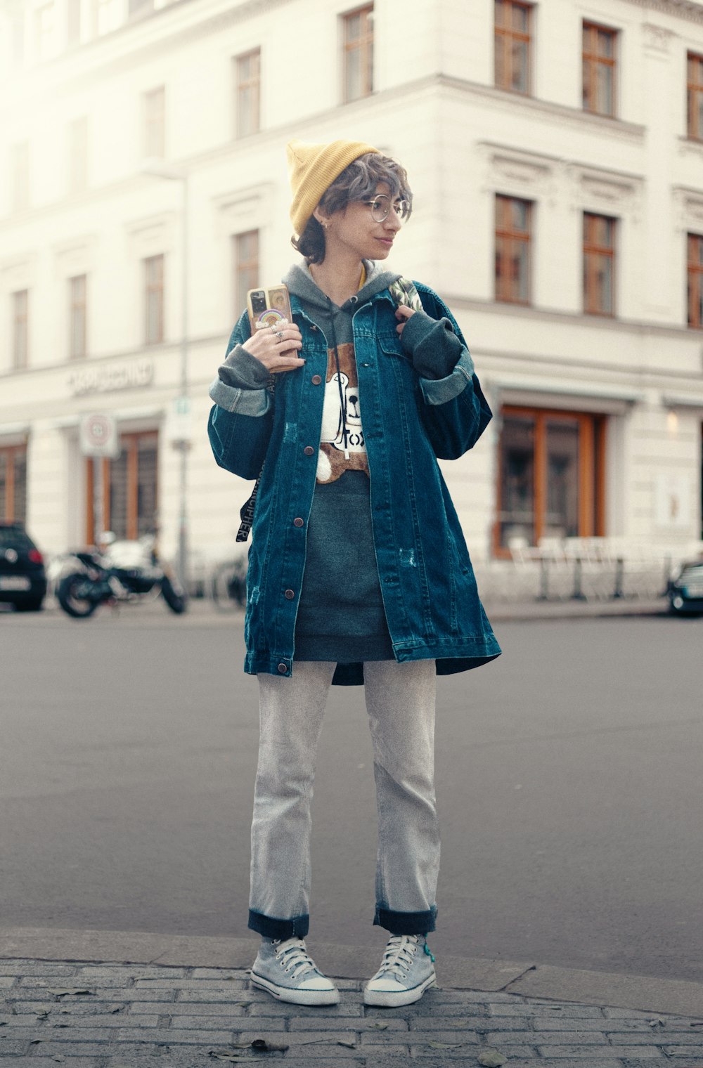 a person standing on a sidewalk with a cell phone