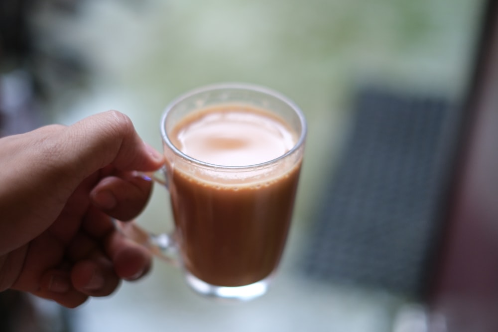 une personne tenant une tasse de café à la main