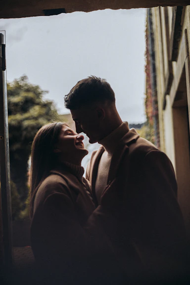 An intimate candid shot of a couple sharing a quiet moment during an outdoor event at dusk