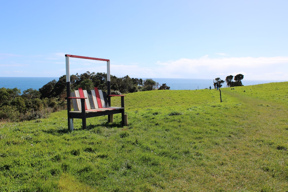 a wooden bench sitting on top of a lush green field