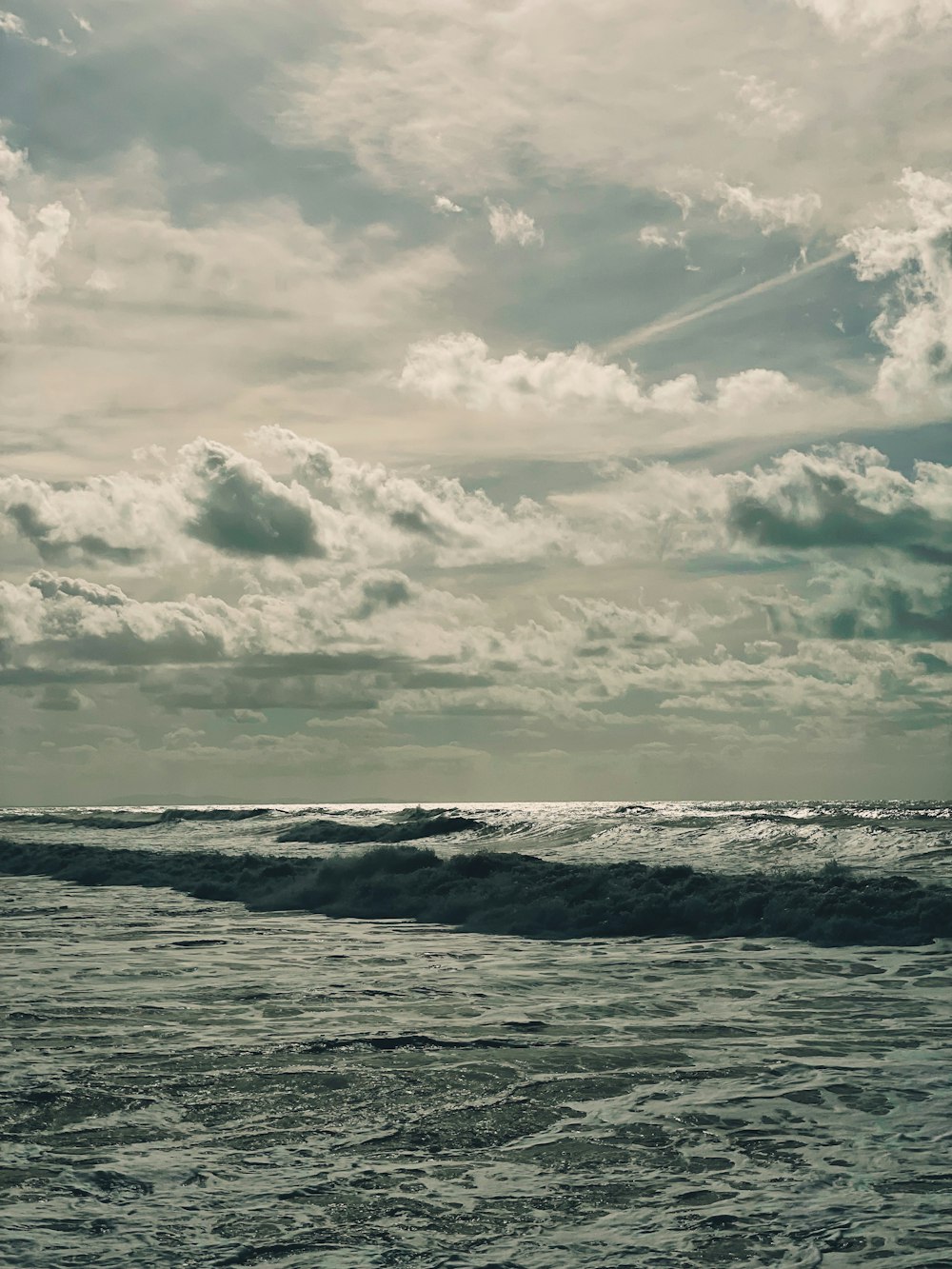 a person walking on the beach with a surfboard