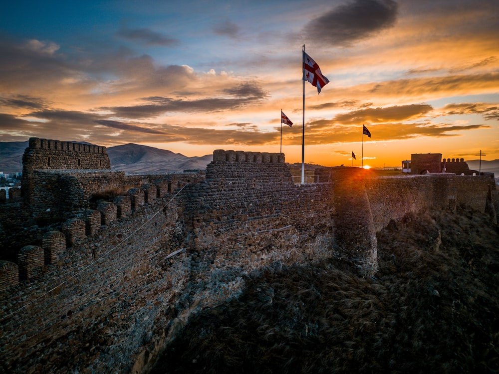 the sun is setting over a castle wall