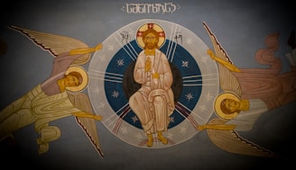 A vibrant mural depicting intertwined symbols from the Bible, Hinduism, and Islam painted on a wall in Nepal.