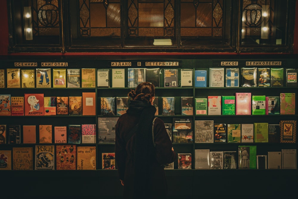 a person standing in front of a wall of books