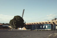 Wide view of an empty commercial lot framed by modern buildings and leafy trees.