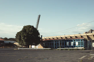 Wide view of an empty commercial lot framed by modern buildings and leafy trees.