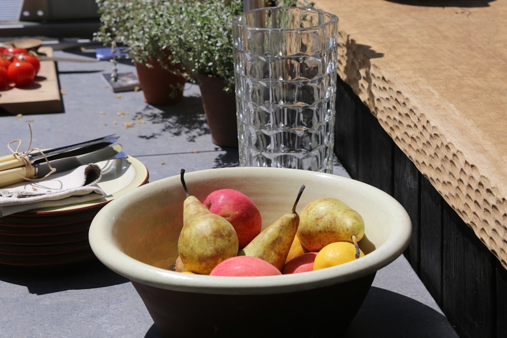 a bowl of fruit sitting on a table