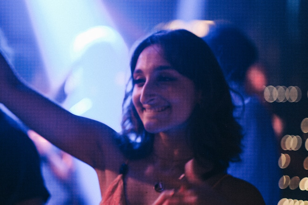 a woman standing in front of a crowd holding a cell phone