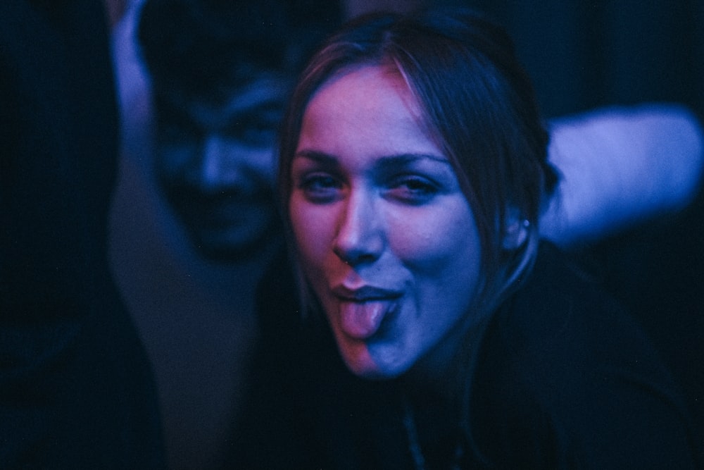 a woman sticking out her tongue in the dark