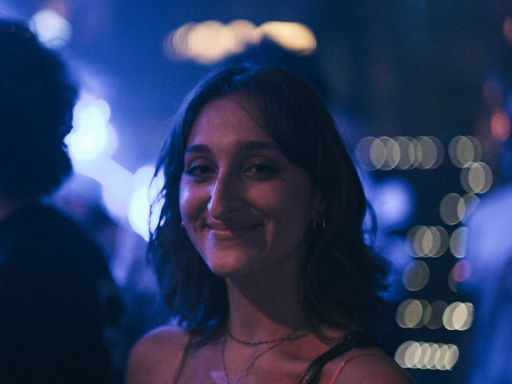a woman is smiling at a party