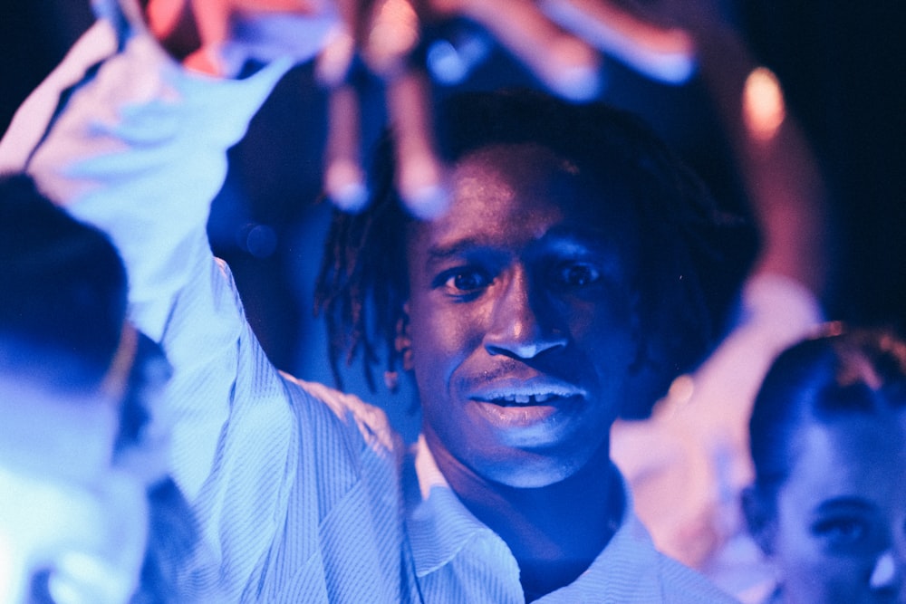 a man holding up his hands in front of a group of people