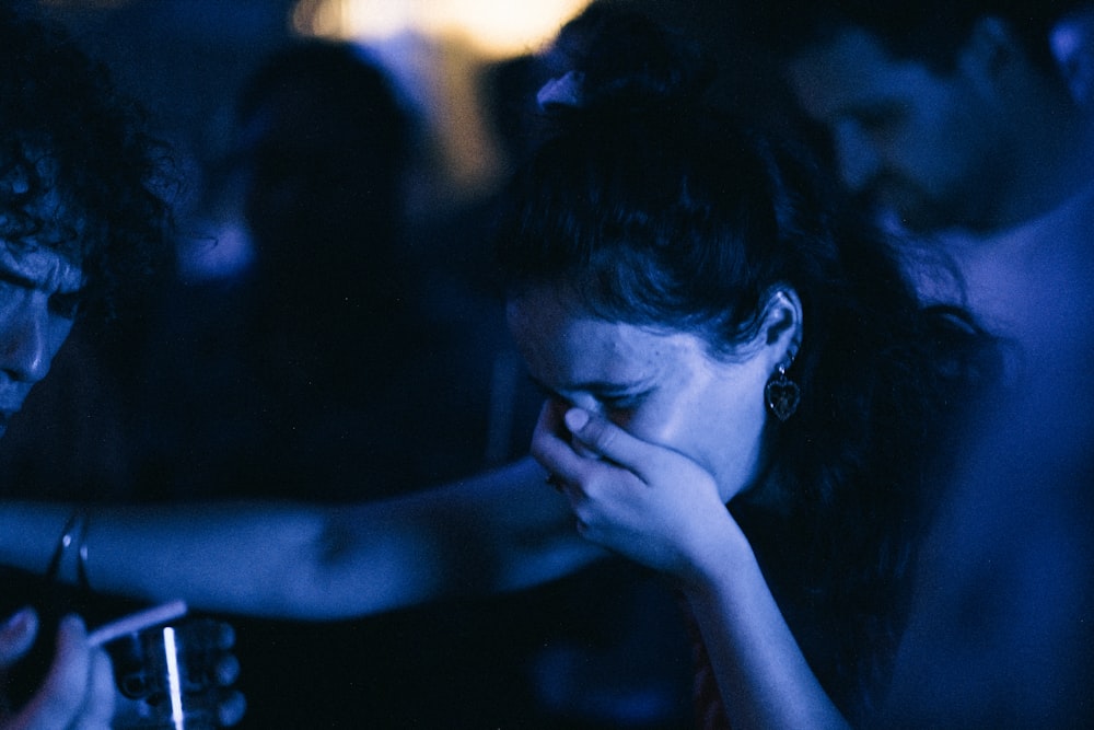 a woman holding a cell phone next to a man