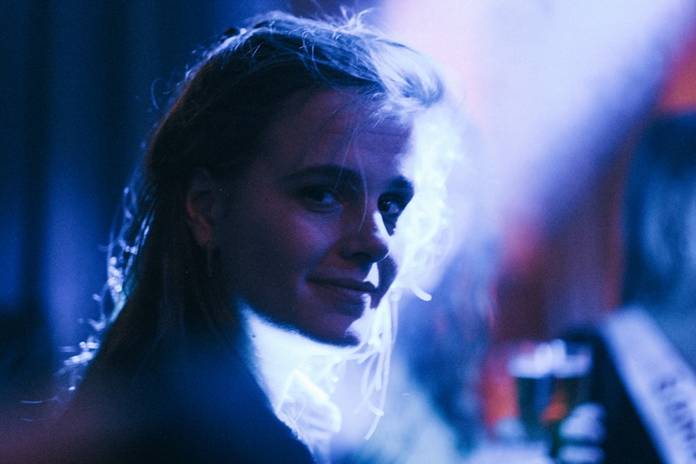 a woman in a dark room with a cigarette in her mouth