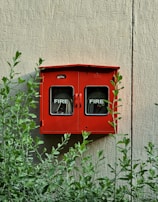 a red fire hydrant mounted to the side of a building