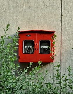 a red fire hydrant mounted to the side of a building