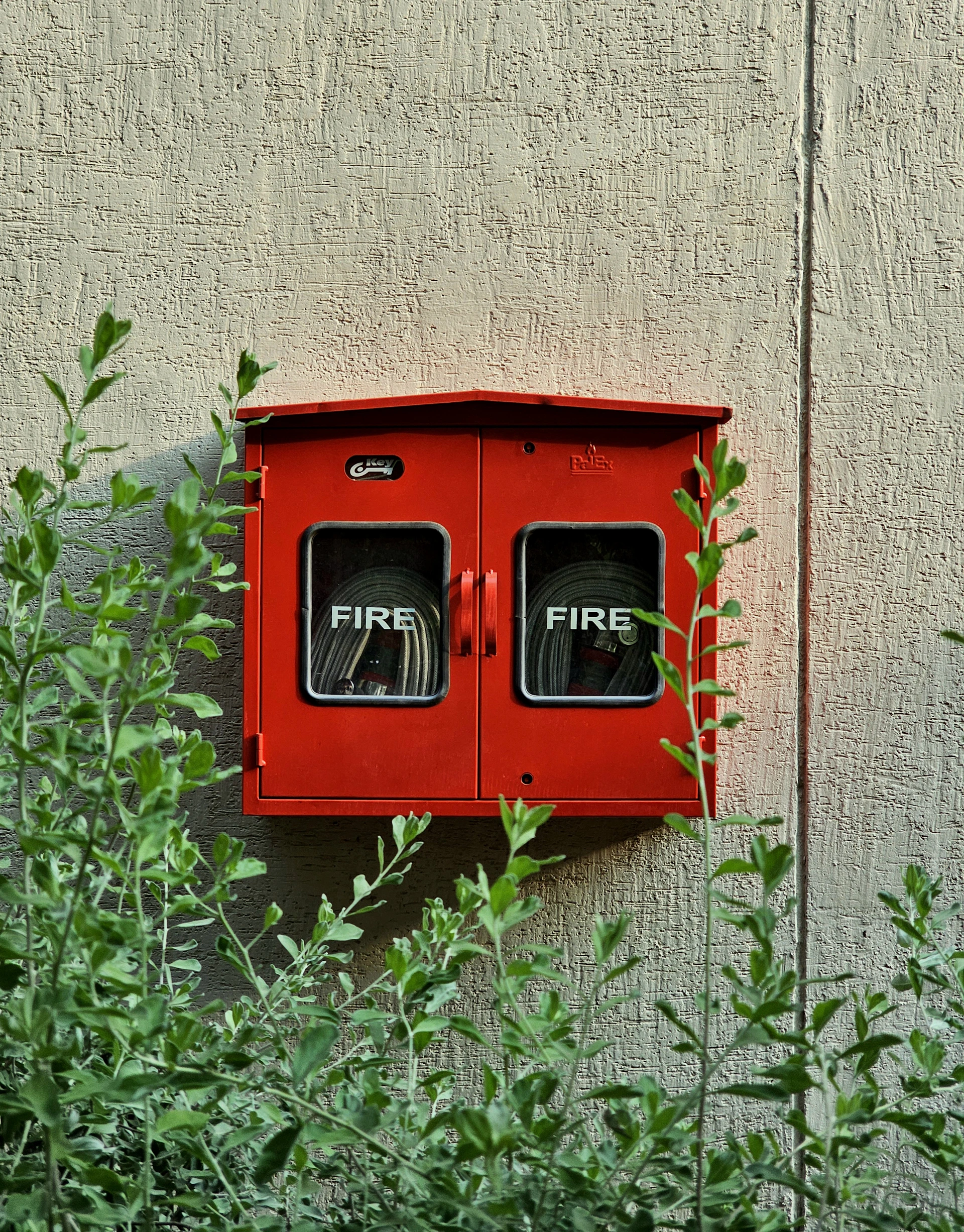 a red fire hydrant mounted to the side of a building