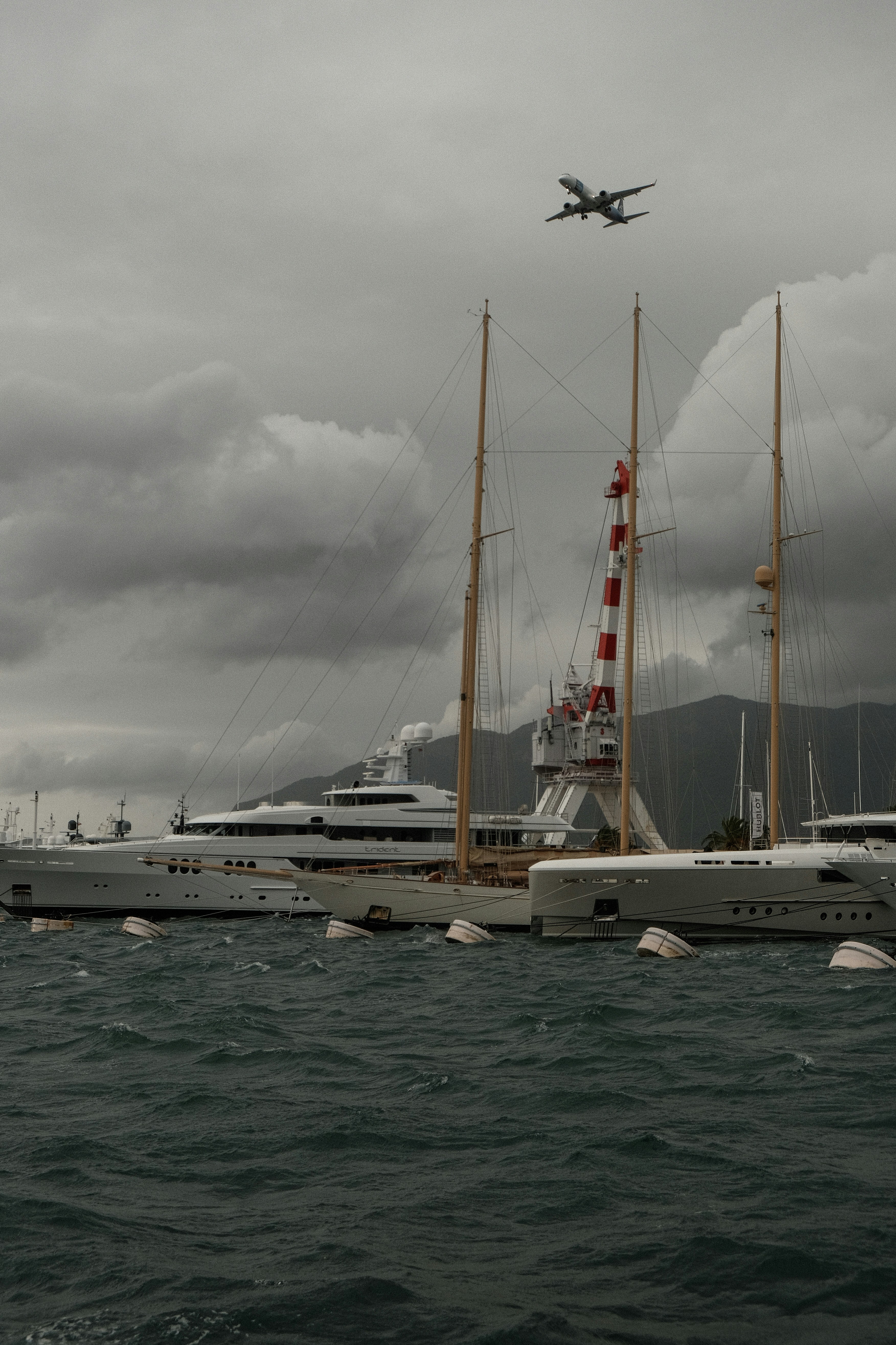 a plane flying over a large boat in the ocean