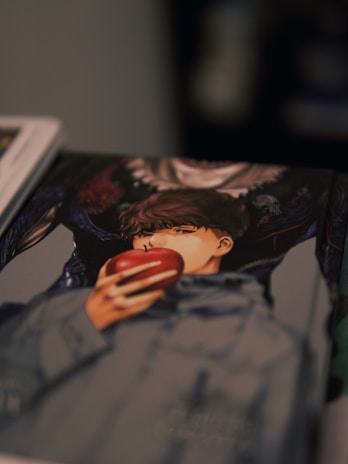 An illustrated image on a book cover features a person with brown, wavy hair holding a red apple. The person is wearing a gray hoodie. The background consists of dark, shadowy figures adding a mysterious atmosphere.